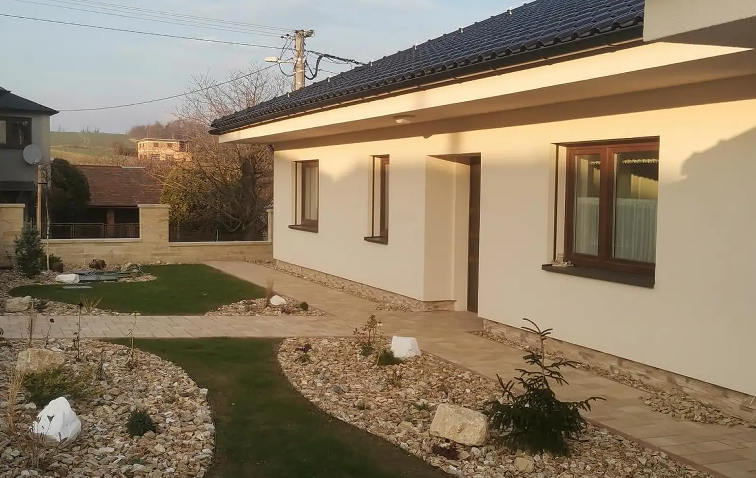 Nově realizovaná zahrada v Hlubočci s okrasnými kameny a výsadbou kolem rodinného domu